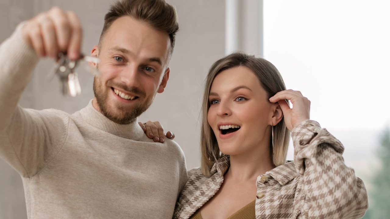 A young couple holding the keys to their new home